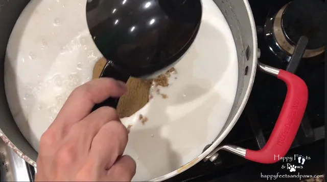 person adding brown sugar to coconut milk for biko recipe