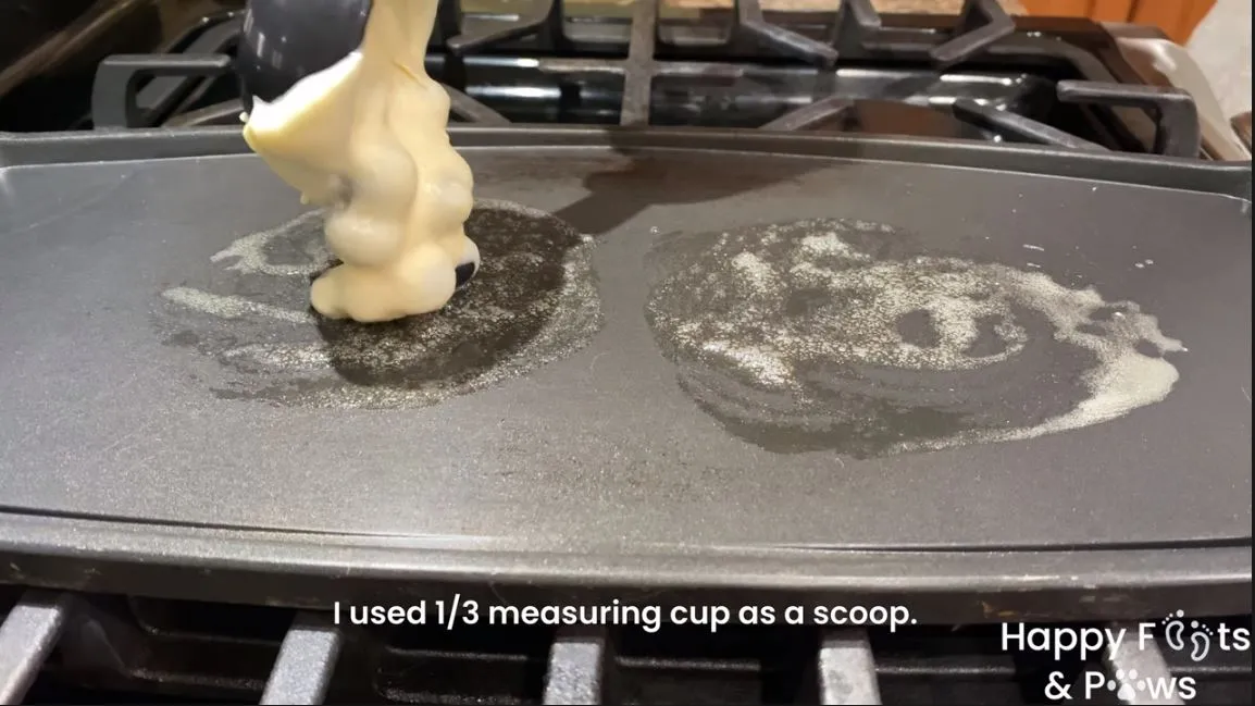 Placing blueberry pancake batter on a buttered hotplate