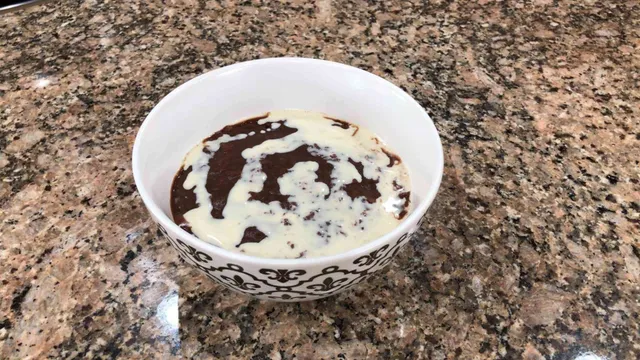 champorado in bowl with milk on top