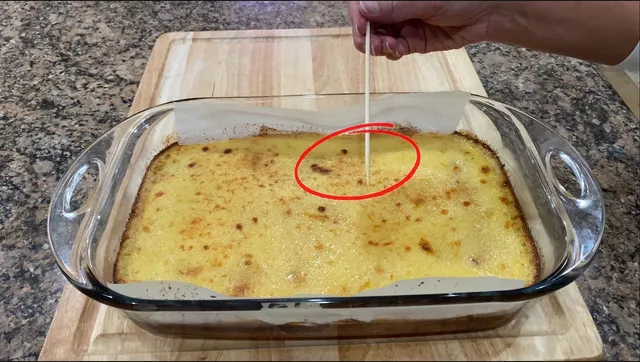 Checking to see if the Cassava cake is cooked using a small wooden stick