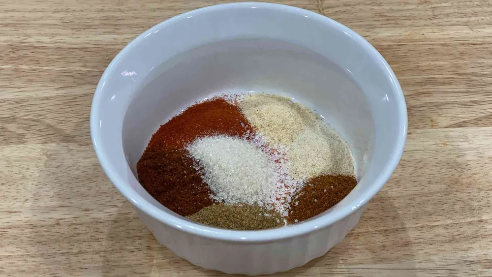 Fajita Seasoning in a bowl with cumin, chili powder, paprika, garlic powder, onion powder, cayenne pepper, kosher salt, and brown sugar