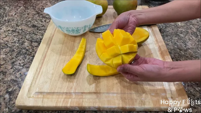 Woman splitting open sliced mango