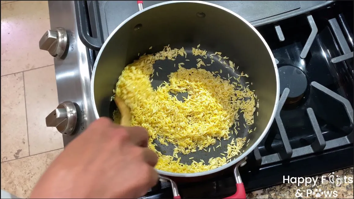 woman's hand stirring rice in pot on stove for Spanish rice recipe