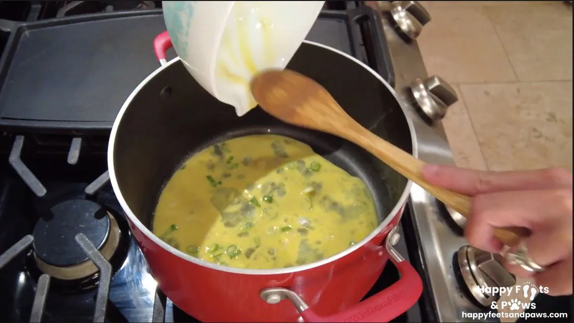 eggs being scrambled with spring onions in a pot for Lap Xuong Fried Rice recipe