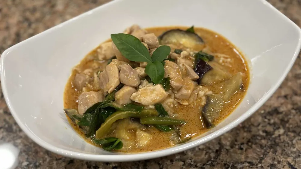 Bowl of panang thai curry with chicken. Includes Chicken, beans, eggplant, basil, and peanutbutter