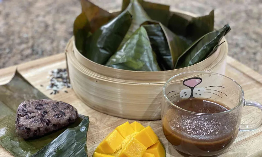 Filipino Puto Maya or Sticky Rice Cake with Sikwate on a cutting board