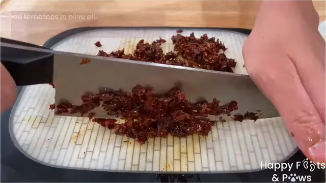 Chopping sundried tomatoes on a cutting board