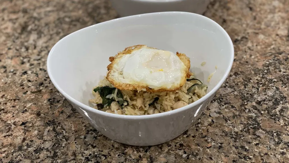 thai chicken fried rice with basil in a bowl. Fried egg on top
