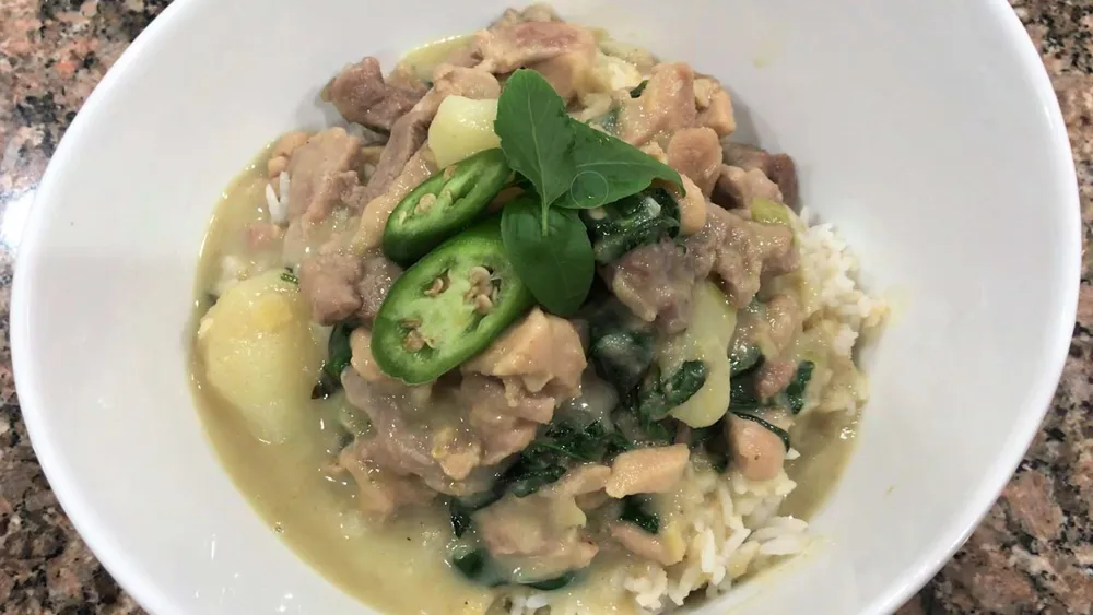 homemade thai green curry in a bowel with fresh basil and peppers