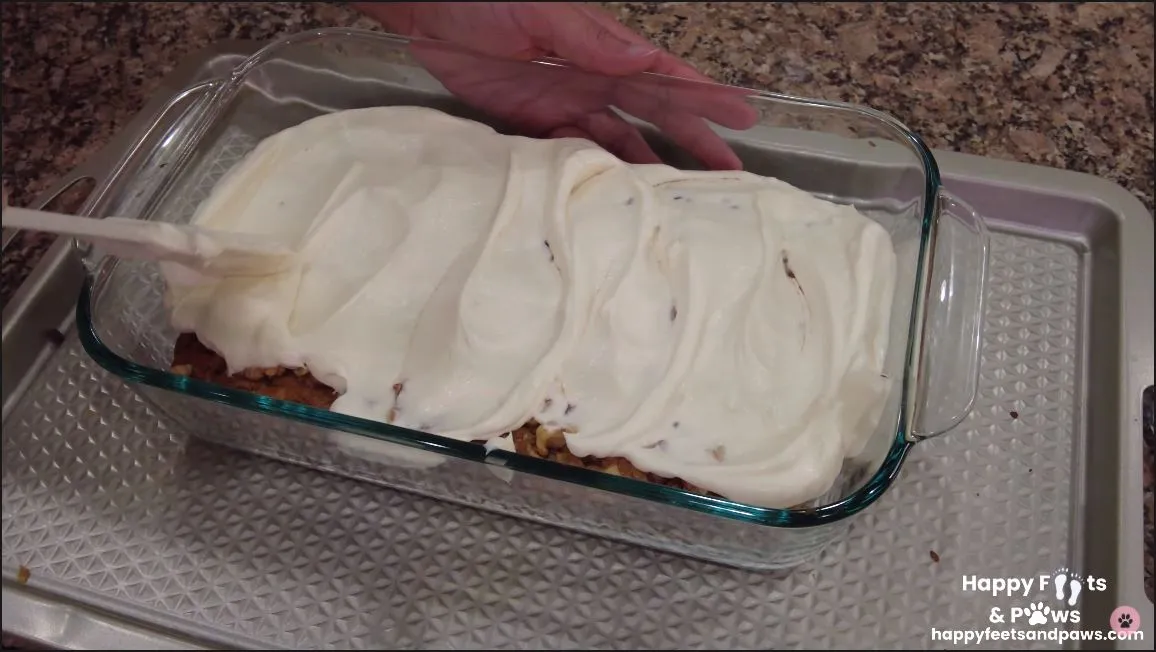 cream cheese frosting being spread on zucchini bread