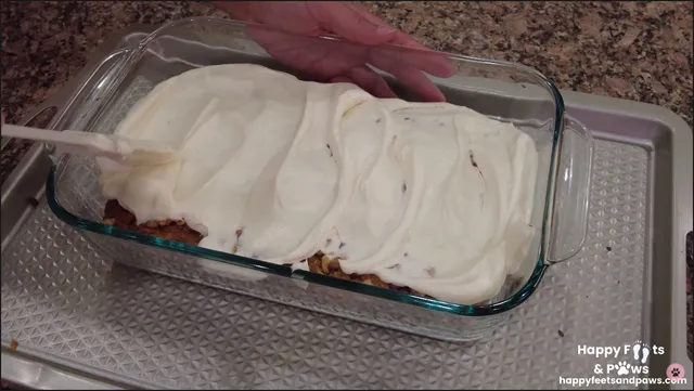 cream cheese frosting being spread on zucchini bread